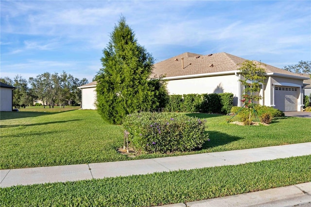 view of side of property featuring a yard and a garage