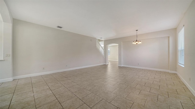 spare room featuring a chandelier