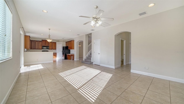 unfurnished living room featuring ceiling fan and light tile patterned flooring