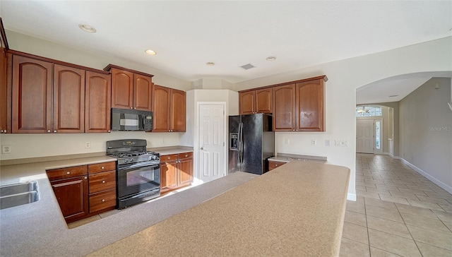 kitchen featuring black appliances, light tile patterned floors, and sink