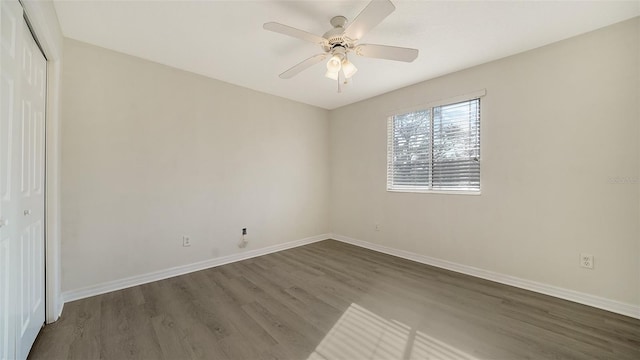 unfurnished bedroom with dark hardwood / wood-style flooring, a closet, and ceiling fan