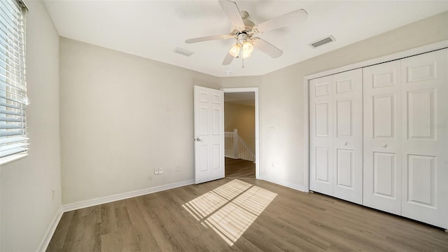 unfurnished bedroom featuring ceiling fan, light hardwood / wood-style floors, and a closet