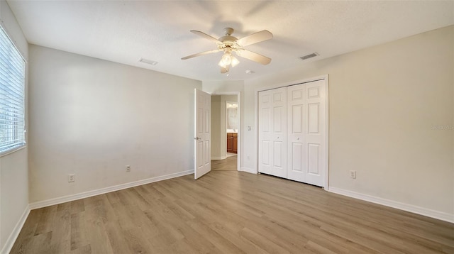 unfurnished bedroom featuring a closet, ceiling fan, and light hardwood / wood-style flooring