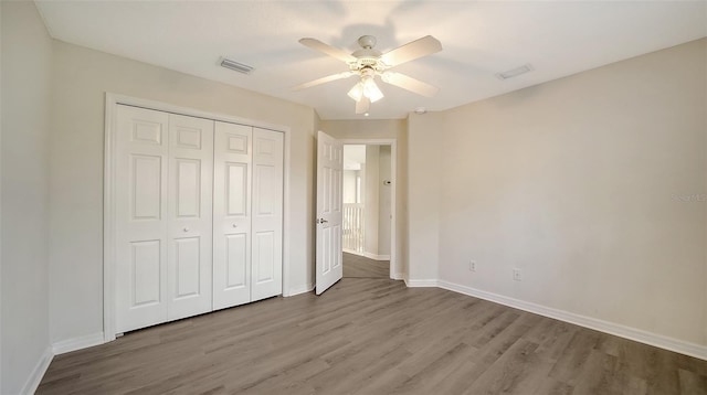 unfurnished bedroom with light wood-type flooring, a closet, and ceiling fan