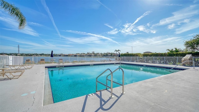 view of swimming pool featuring a water view and a patio area