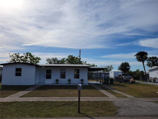 view of front of property featuring a front yard and a carport