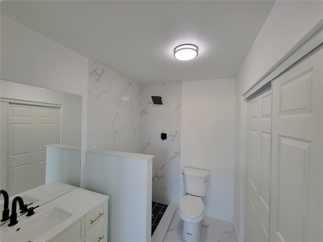 bathroom featuring vanity, a tile shower, a textured ceiling, and toilet