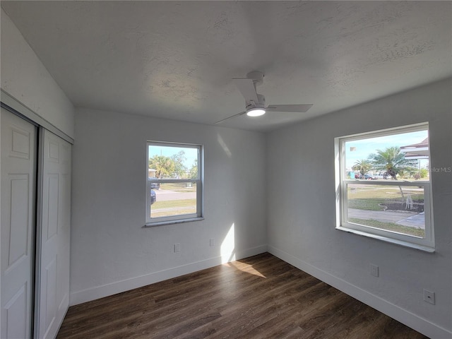 unfurnished bedroom with a closet, ceiling fan, dark hardwood / wood-style flooring, and a textured ceiling