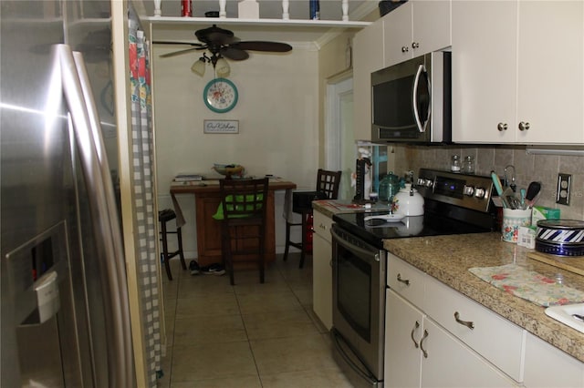 kitchen featuring backsplash, white cabinets, ceiling fan, light tile patterned floors, and appliances with stainless steel finishes