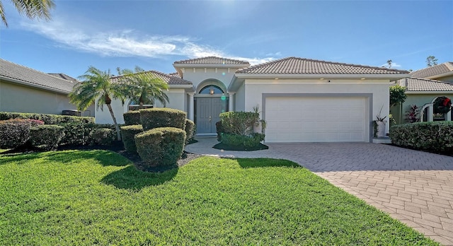 mediterranean / spanish-style home with a front yard and a garage