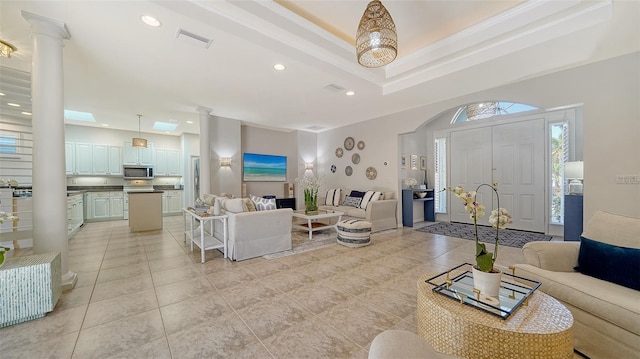 living room featuring decorative columns and light tile patterned floors