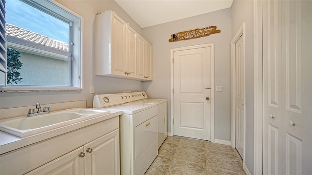 laundry area with cabinets, independent washer and dryer, sink, and a wealth of natural light