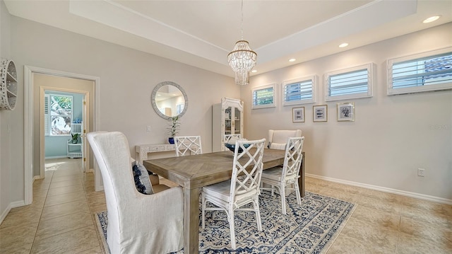 dining space featuring a notable chandelier, light tile patterned flooring, and a raised ceiling