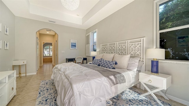 tiled bedroom featuring a tray ceiling