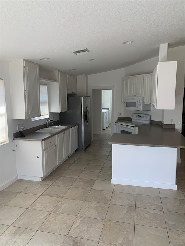 kitchen featuring white cabinetry, sink, kitchen peninsula, washer / clothes dryer, and white appliances