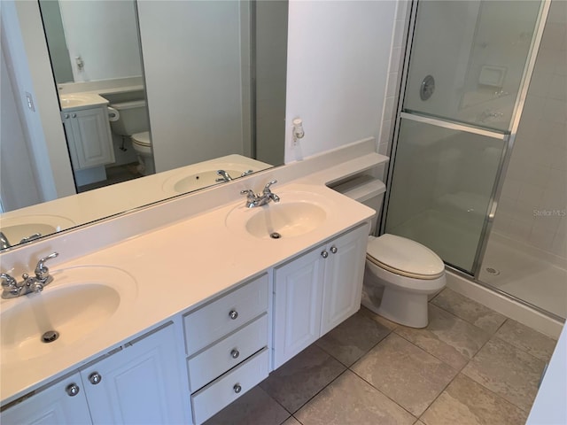 bathroom with tile patterned flooring, vanity, toilet, and a shower with shower door