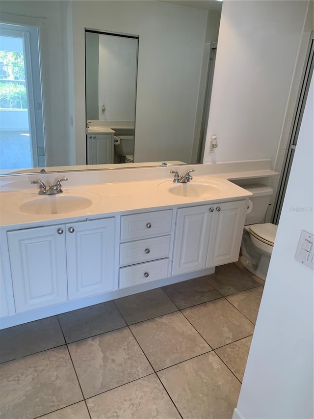 bathroom featuring tile patterned flooring, vanity, and toilet