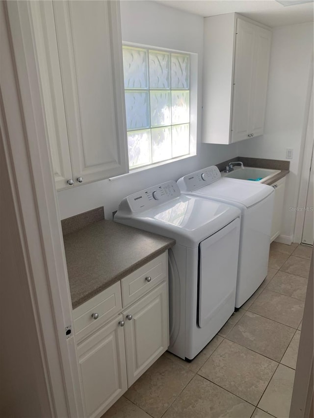 laundry area featuring sink, light tile patterned floors, cabinets, and independent washer and dryer