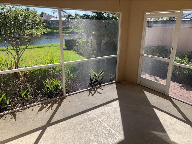 sunroom / solarium featuring a water view