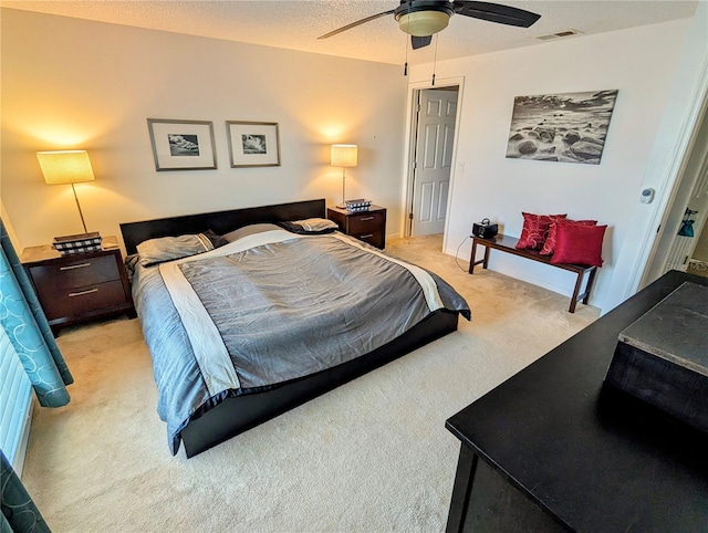 carpeted bedroom with ceiling fan and a textured ceiling