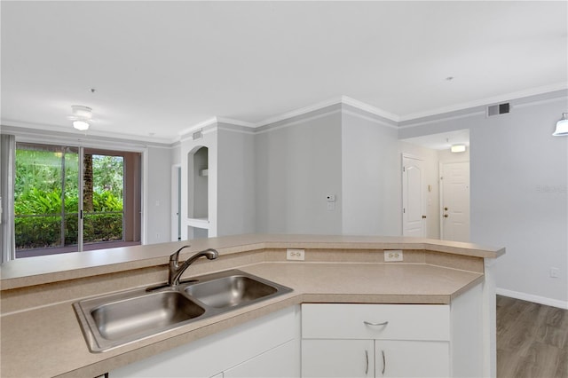 kitchen with sink, crown molding, white cabinets, and light wood-type flooring