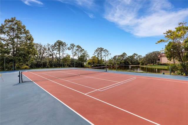 view of sport court featuring basketball hoop and a water view