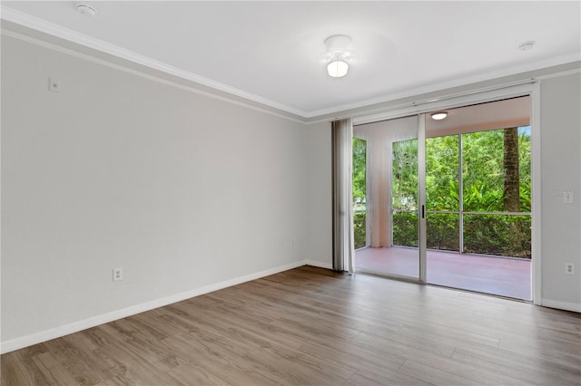 unfurnished room with hardwood / wood-style flooring and ornamental molding