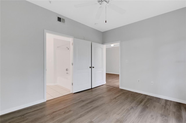 unfurnished bedroom featuring ceiling fan, connected bathroom, and light hardwood / wood-style floors