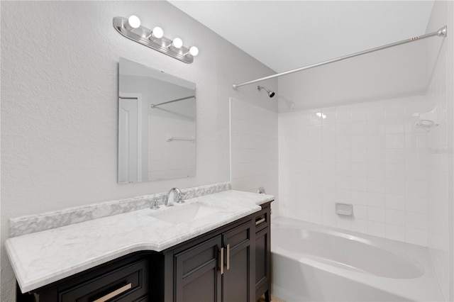 bathroom with tiled shower / bath combo and vanity