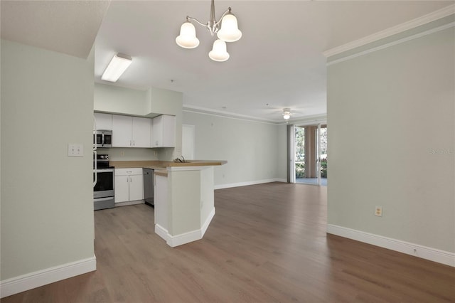 kitchen featuring decorative light fixtures, white cabinetry, hardwood / wood-style flooring, kitchen peninsula, and stainless steel appliances