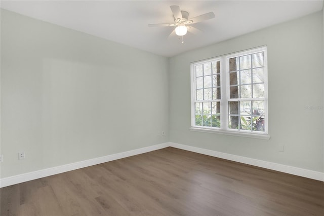 unfurnished room featuring dark wood-type flooring and ceiling fan