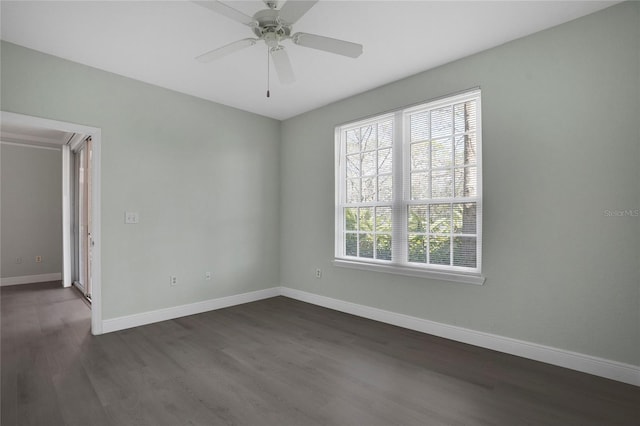 spare room with dark wood-type flooring and ceiling fan