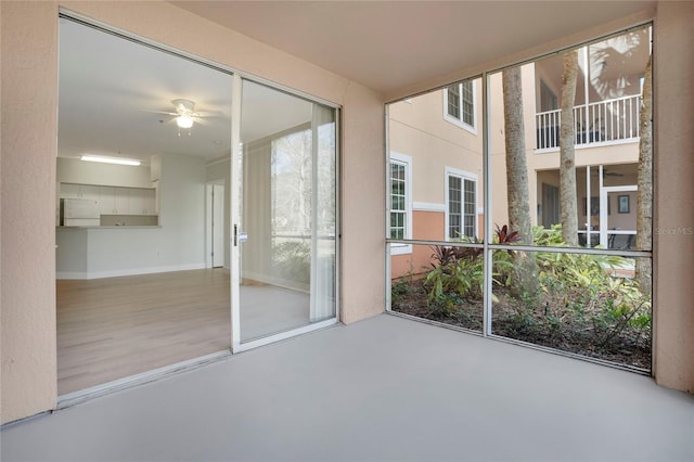 unfurnished sunroom featuring ceiling fan