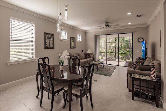 dining area with ceiling fan, crown molding, and light tile patterned floors