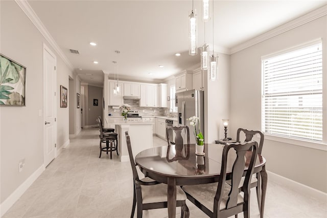 dining room with a healthy amount of sunlight, ornamental molding, and light tile patterned floors