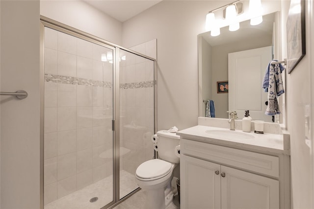 bathroom with vanity, toilet, and a shower with door