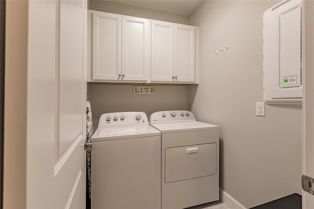 clothes washing area with cabinets and washing machine and dryer