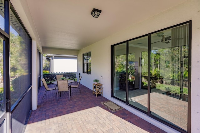 unfurnished sunroom featuring ceiling fan