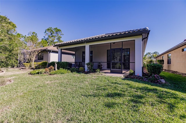 back of house featuring a yard and a sunroom