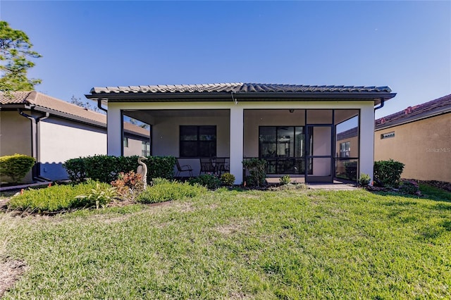 back of house featuring a sunroom and a lawn