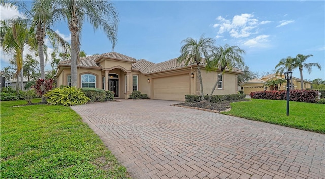 mediterranean / spanish home with a front yard and a garage