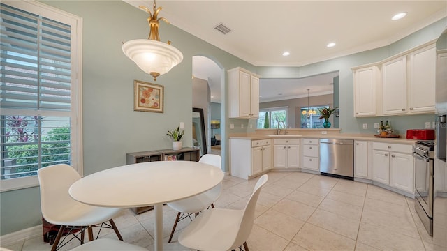 kitchen with sink, hanging light fixtures, light tile patterned floors, ornamental molding, and appliances with stainless steel finishes