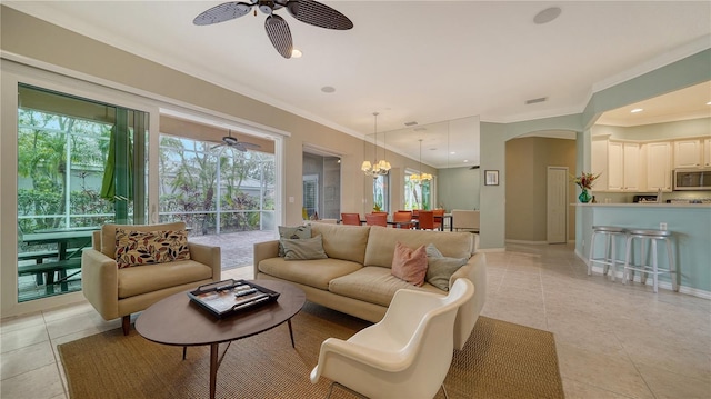 tiled living room with ceiling fan with notable chandelier, a wealth of natural light, and ornamental molding