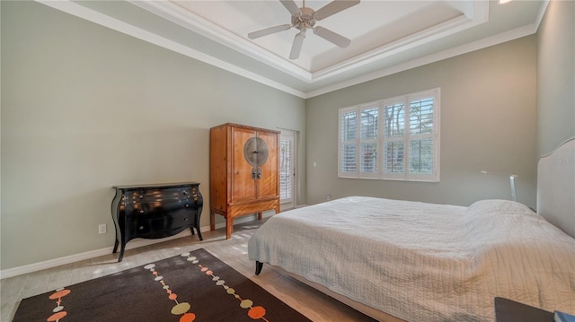 bedroom featuring ceiling fan, light hardwood / wood-style floors, a raised ceiling, and ornamental molding