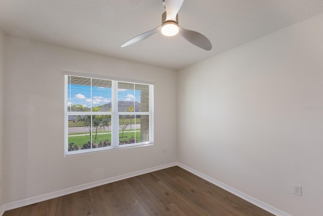 empty room with ceiling fan and dark hardwood / wood-style flooring