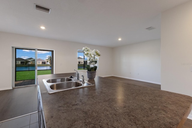 kitchen featuring an island with sink, sink, and dark hardwood / wood-style floors