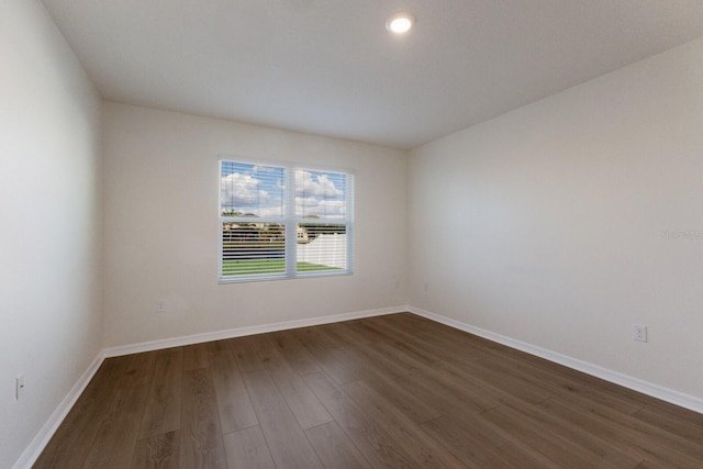 unfurnished room with dark wood-type flooring