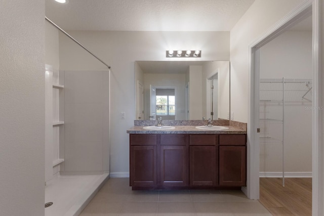 bathroom with vanity, a textured ceiling, and walk in shower