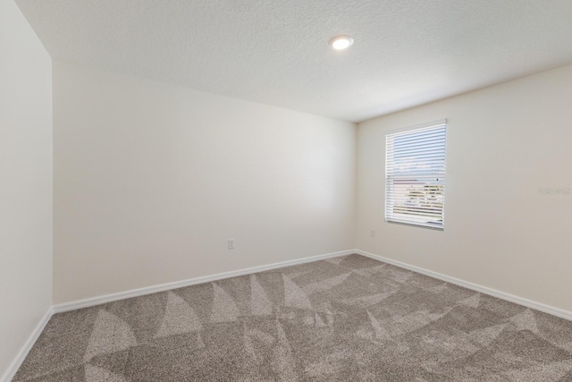 carpeted spare room featuring a textured ceiling