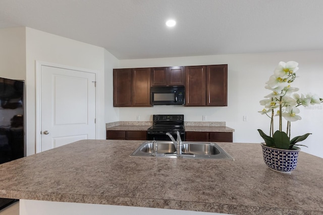 kitchen with dark brown cabinetry, sink, black appliances, and a center island with sink